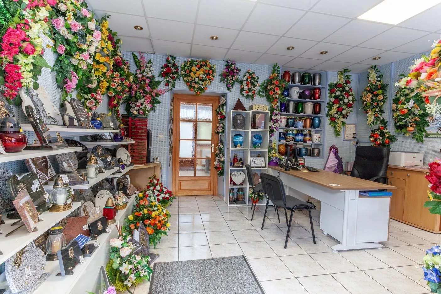 Vue d'ensemble de la boutique avec plaques commémoratives, compositions florales et bureau